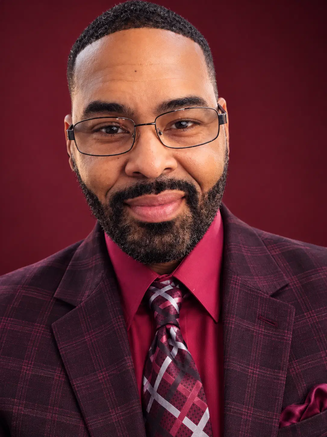 Trevor Bonner wearing glasses and a burgundy suit